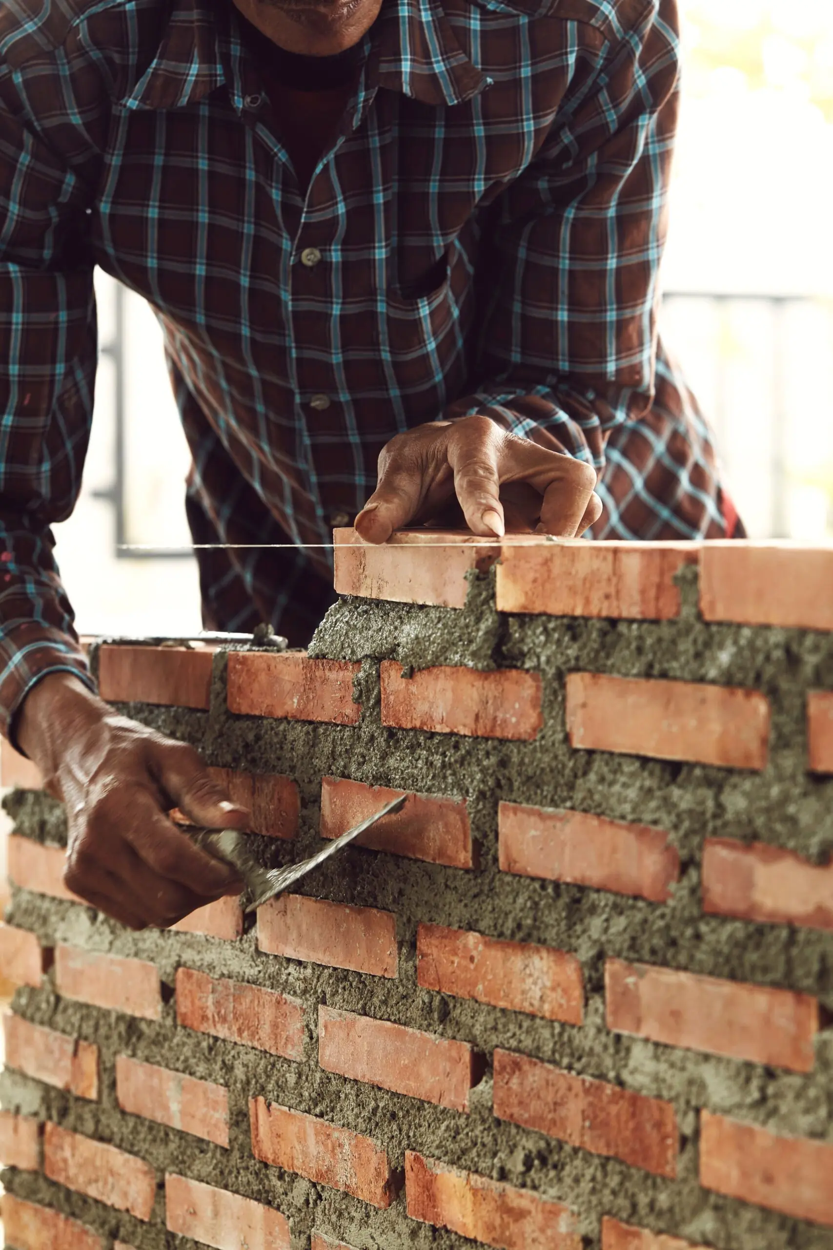 bricklayer worker installing brick masonry