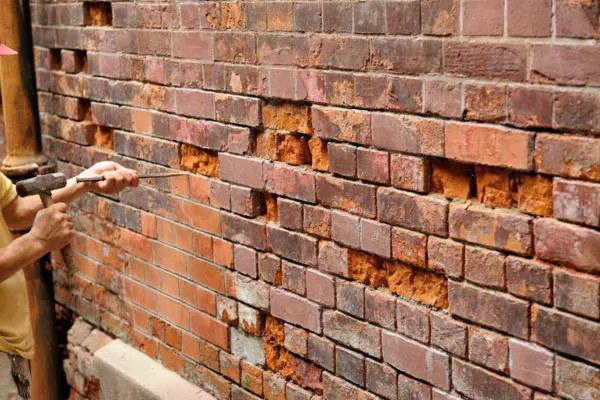 a man repairing old masonry brick walls