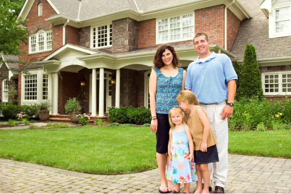 happy family in front of brick house