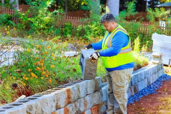 retaining wall construction by masonry worker