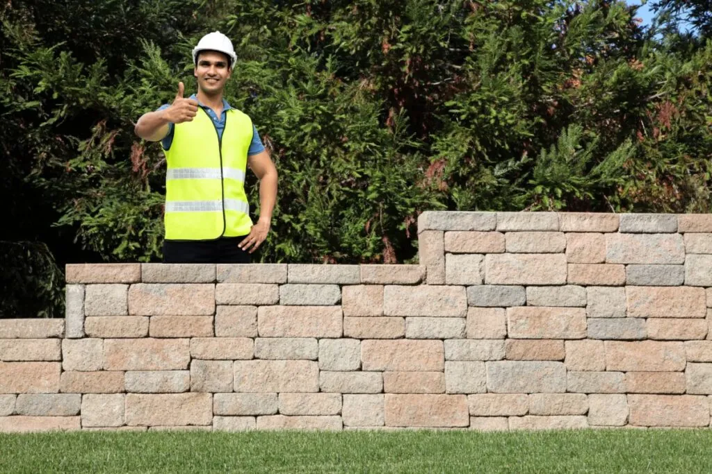 contractors thumbs up after finishing the retaining wall