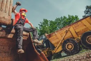 grading contractor sitting in the backhoe machine