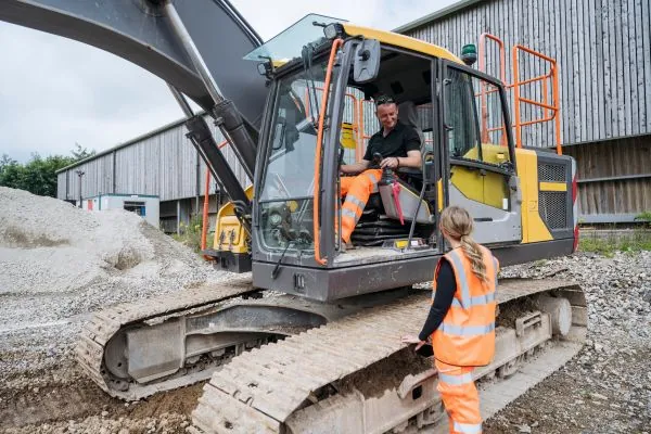 male operating excavator machine at site 