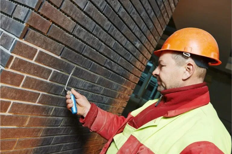 Masonry contractor repairing brick wall