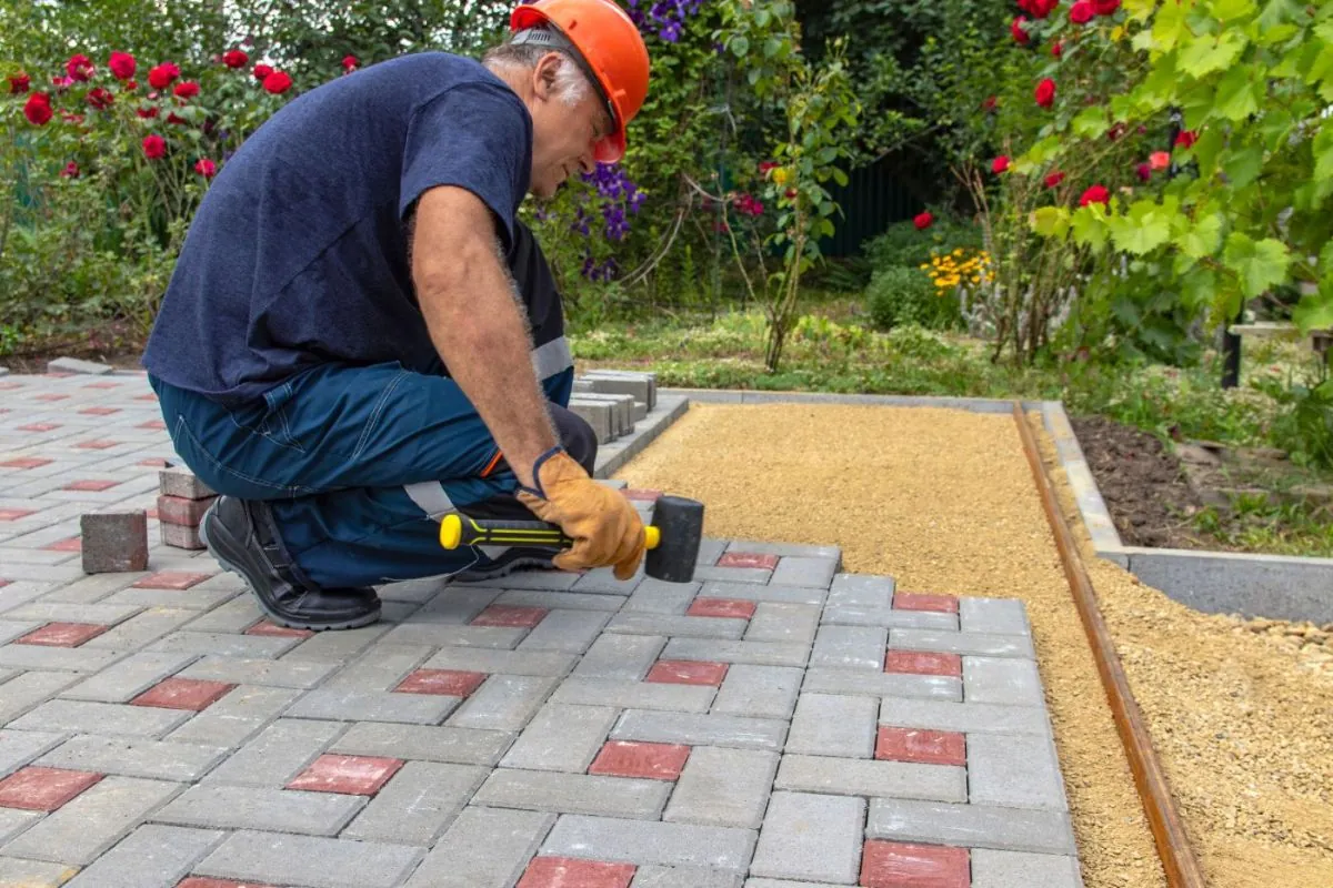 a contractor installing patio on backyard using pavers