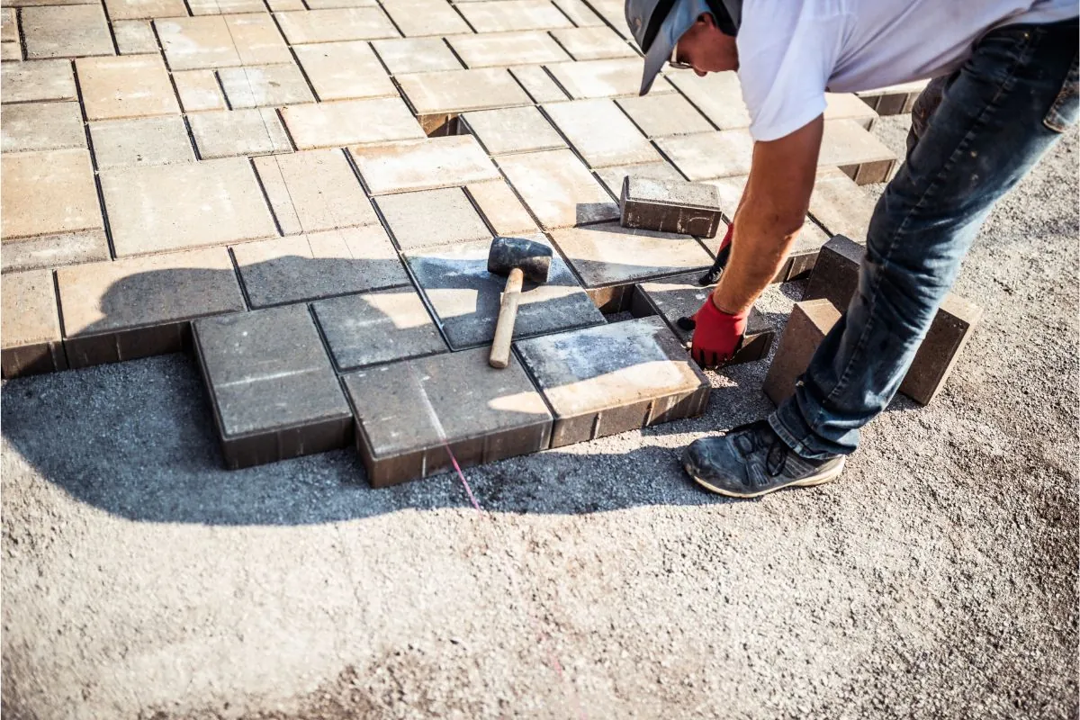 young man installing paving stones